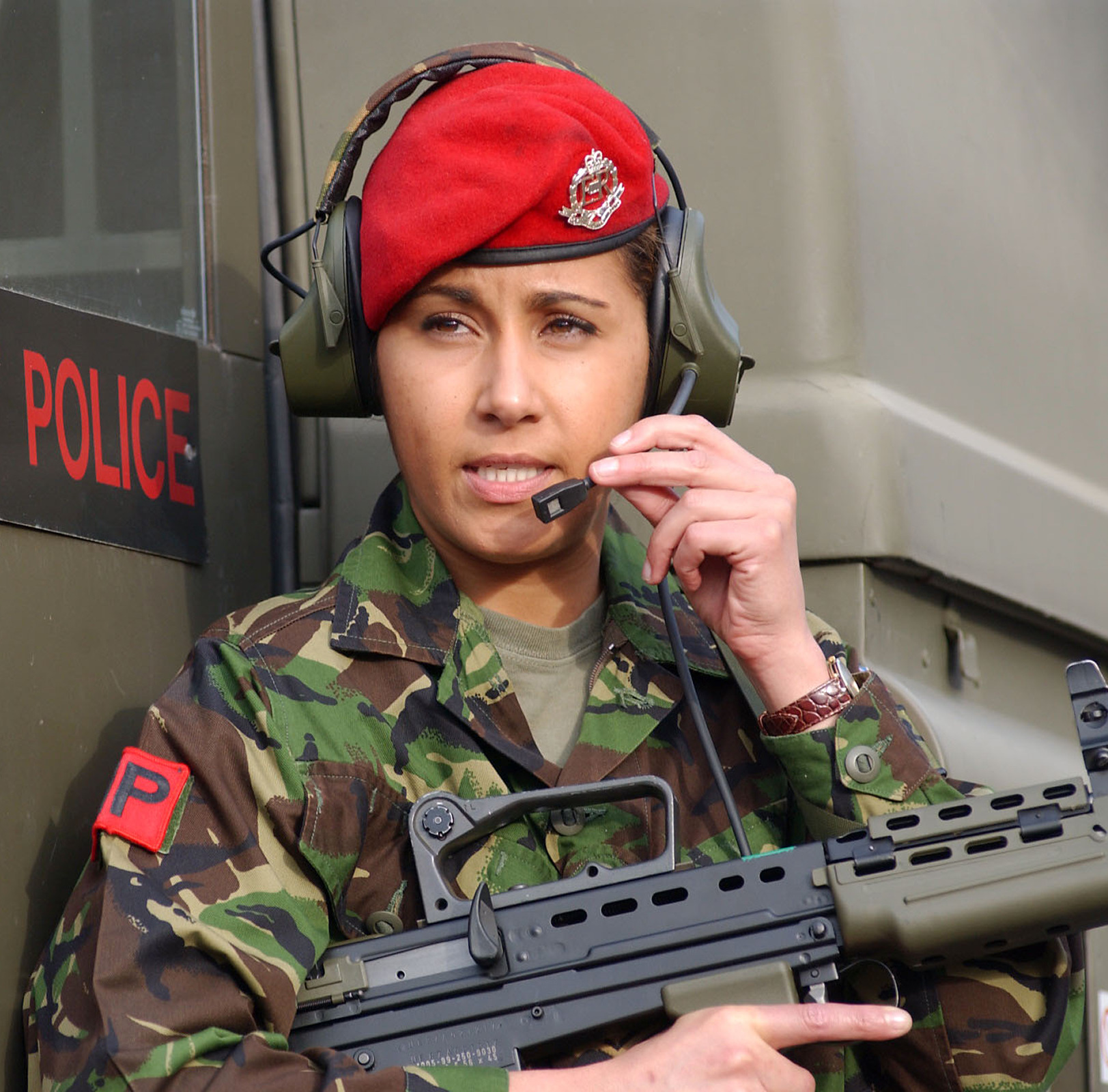 Soldier with red beret and headset holding rifle