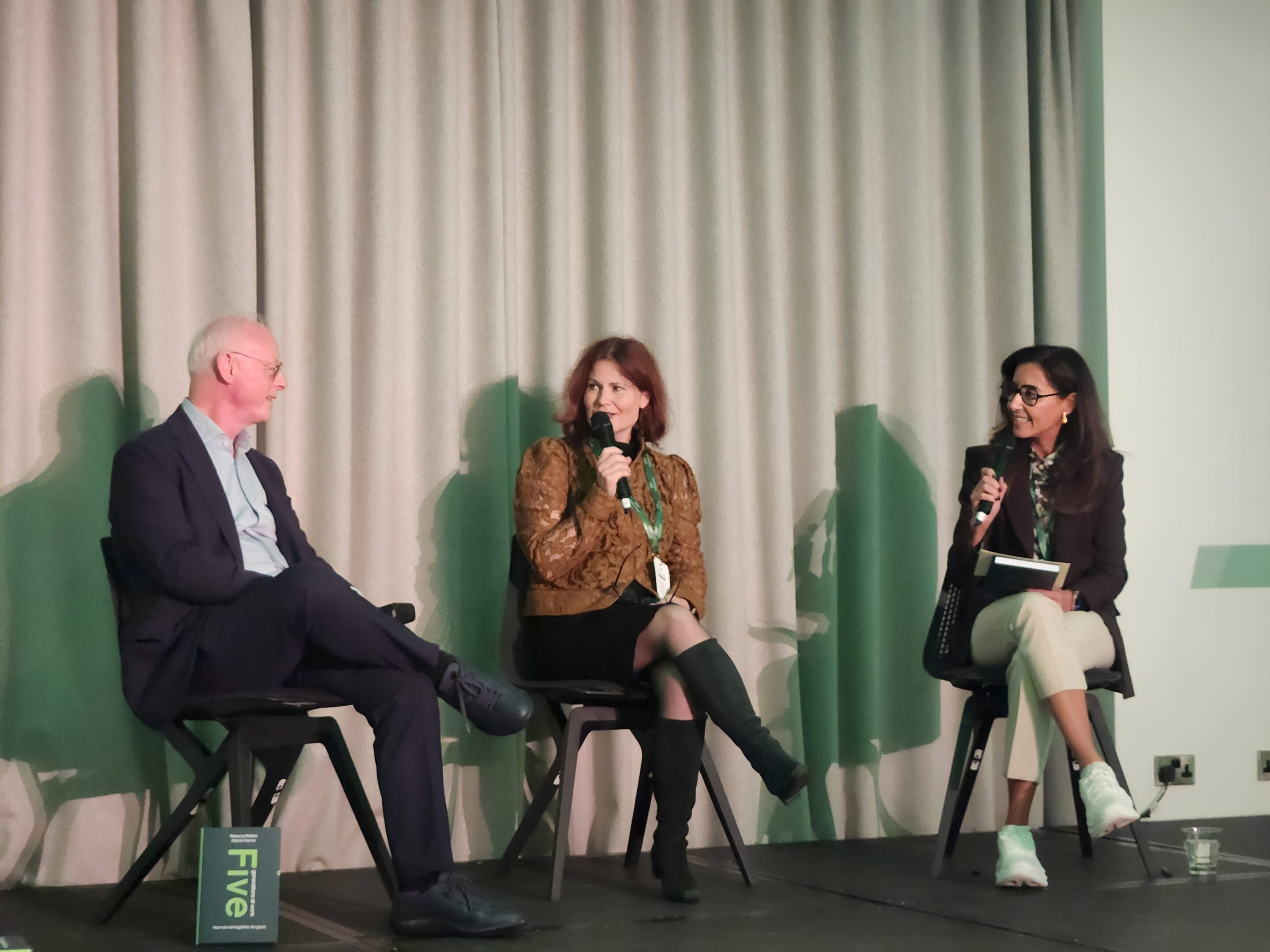 Three people in panel discussion on stage
